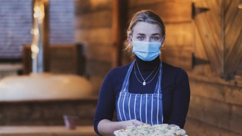 Waitress holding garlic bread