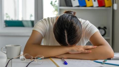 Woman with head on hands struggling to study