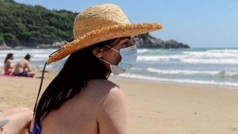 Woman on a beach wearing a face mask