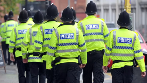 Police officers on patrol wearing high vis jackets and helmets
