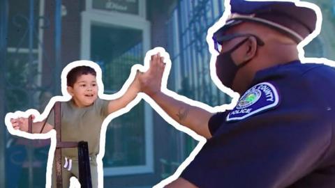 A police officer high fives a young child