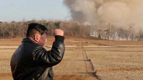 Video shows the North Korean leader speaking to military officials as rockets fire into the sky.