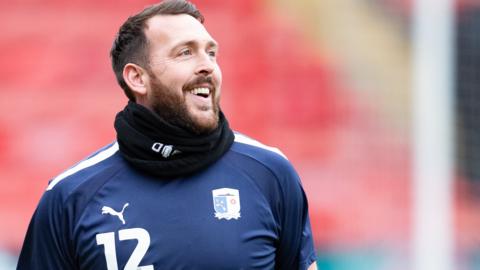 Josh Lillis smiles as he warms up for Barrow before a game at Walsall