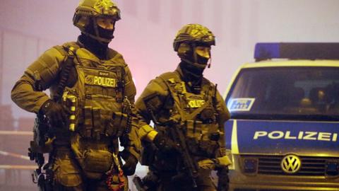 Riot police armed with machine guns patrol the street in front of Pasing railway station on 1 January, 2016 in Munich, Germany