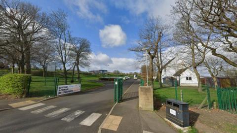 The entrance to Prudhoe Community High School with a panel to one side and a poster saying "attendance matters".
