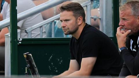 Tom Cleverley sits in the dugout at Home Park watching a Plymouth game.