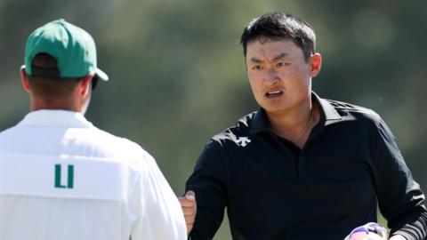 Li Haotong fist bumps his caddie at the 2026 Masters