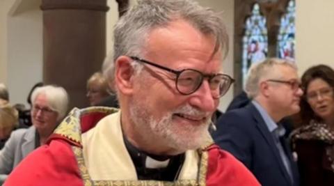 Nigel Godfrey in ceremonial robes of red and cream.