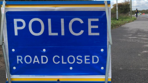 A police road closed sign