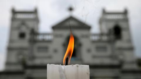 A candle burns outside St Anthony's Shrine one week after the Easter Sunday attacks in Sri Lanka