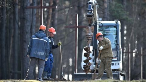 Workers removing crosses at Kuropaty, 4 Apr 19