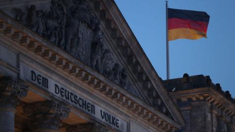 A German flag flies over the Reichstag, seat of the Bundestag, Germany's parliament