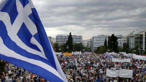 Greek flag and protestors