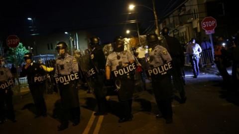 Police officers stand guard outside a police station in Philadelphia