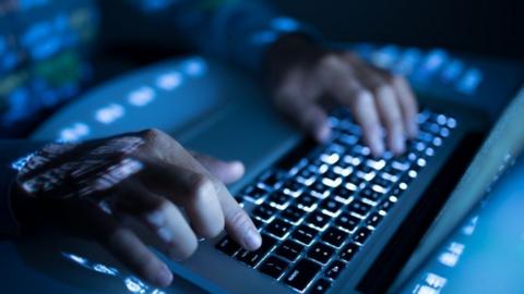 A person typing on a laptop computer