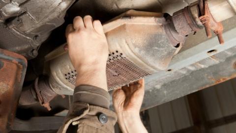 A catalytic converter being removed from an SUV car