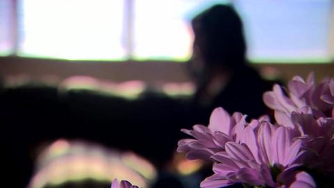 An anonymised abuse survivor tells her story with a pink flower in shot