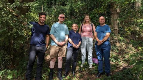 Phil Sturgeon and four other people standing in woodland, including MP Kerry McCarthy