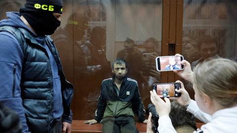 Shamsidin Fariduni, a suspect in the shooting attack at the Crocus City Hall concert venue, sits behind a glass wall of an enclosure for defendants before a court hearing at the Basmanny district court in Moscow, Russia March 25, 2024