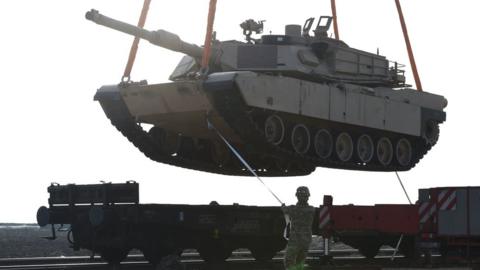 A US soldier helps to manoeuvre a tank from a railway car as part of the 'Atlantic Resolve' NATO mission.