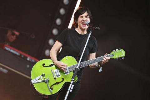 Sharleen Spiteri singing on stage, holding a lime green guitar.