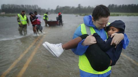 an emergency worker carries a child
