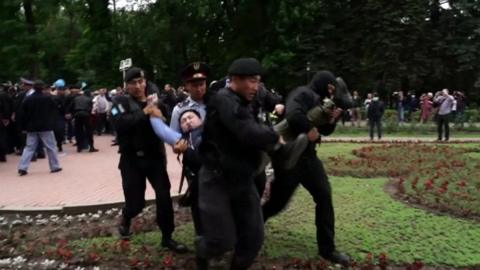Protester being carried away by police in Almaty, Kazakhstan
