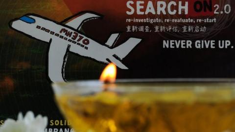 A candle burns a prayer message for passengers of missing Malaysia Airlines flight MH370 in Petaling Jaya on March 8, 2016