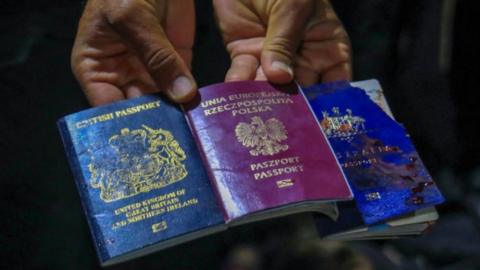 A man holding three passports after an air strike in Gaza