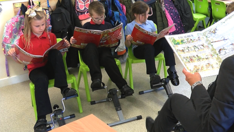 Teacher and three pupils using pedal machines at school