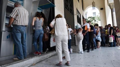 People queuing outside a cashpoint in Greece