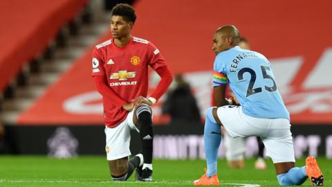 Marcus Rashford of Manchester United and Manchester City's Fernandinho take a knee