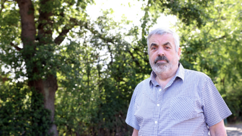 Paul Burns standing next to the 'dangerous' tree branch