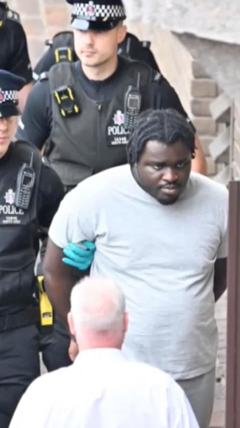 A man being walked in handcuffs.