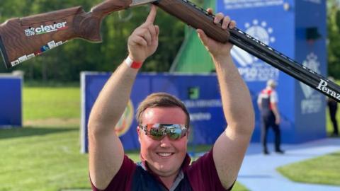 Matthew Coward-Holley celebrates winning trap gold at the 2021 European Shooting Championships