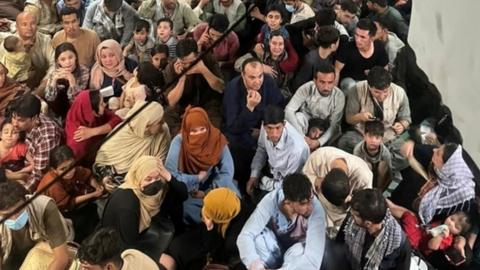 Hundreds of Afghans managed to get on to the half-open ramp of the US Air Force C-17 aircraft in August 2021 as it left Kabul for Qatar