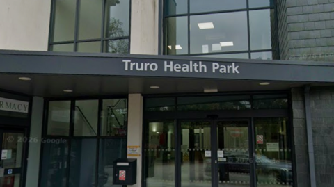 A picture of the entrance to the health park in Truro. There is glass doors and a window, with an automatic door entrance,