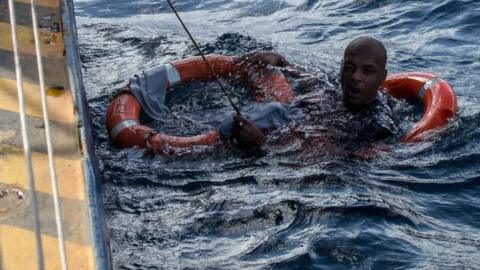 A migrant is rescued from the sea off Malta's coast,