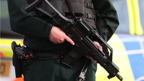 An armed police officer on duty near the sports complex in Omagh where John Caldwell was shot