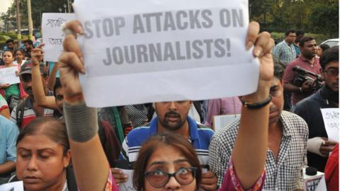 A journalist in India holds a sign reading "Stop attacks on journalists" at a protest in Kolkata, 2017