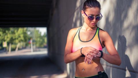 woman looking at fitness tracker on her wrist