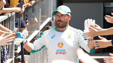 Aaron Finch high-fives fans as he walks out for practice in his final one-day international for Australia