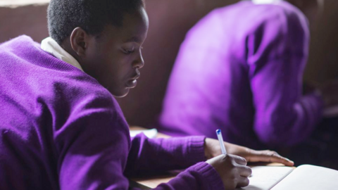 A student taking notes in class, Kisoro, Uganda