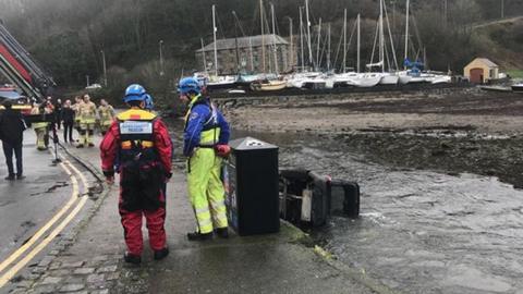 Car in river and rescue crews