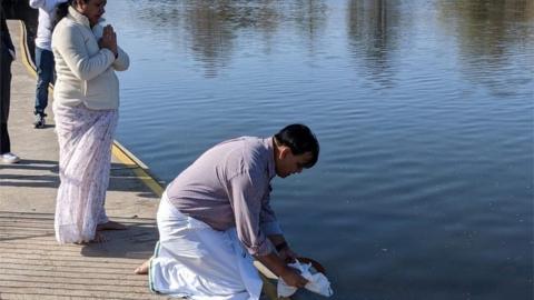 Radhika Kadaba's father's ashes being placed into the river