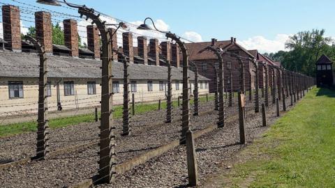 Barbed wire fences and watch tower at the Auschwitz 1 camp