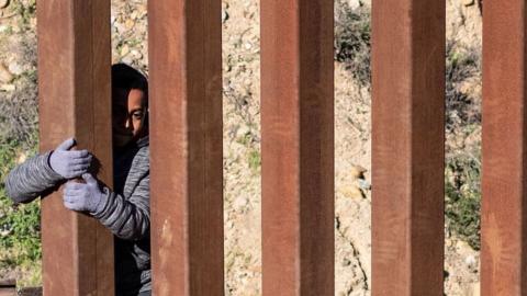 Mexican migrant child Kevin Andres crosses the US-Mexico border fence