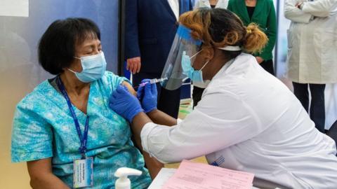 A healthcare worker administers the second dose of the Pfizer-BioNTech coronavirus disease (COVID-19) vaccine to personal support worker Anita Quidangen, who is the first person in Ontario to receive both doses, at The Michener Institute, in Toronto, Canada January 4, 2021