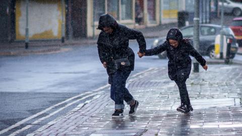 Shoppers running in the rain