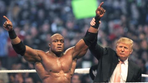 Donald Trump raises the hand of WWE wrestler Bobby Lashley in victory after Lashley defeated Umaga in the Battle of the Billionaires at the 2007 World Wrestling Entertainment's Wrestlemania April 1, 2007 at Ford Field in Detroit, Michigan.